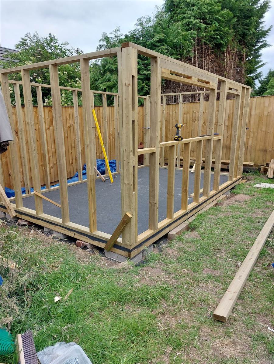 Completed floor frame from the front — joists, rim boards and membrane, pads visible beneath